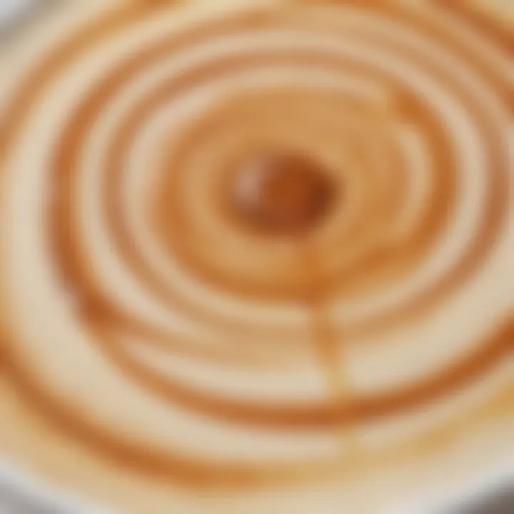 Close-up of caramel drizzle on a frothy latte surface