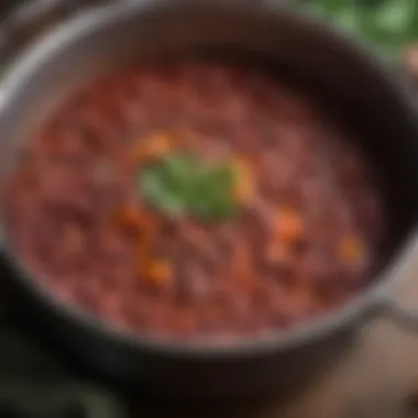 A close-up of red beans simmering in a pot with aromatic vegetables.