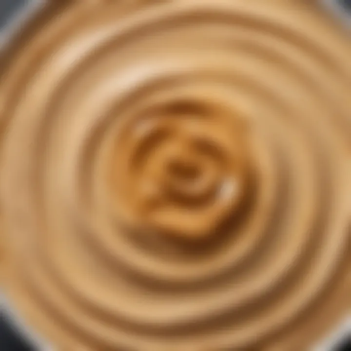 A close-up view of peanut butter being added to a creamy hummus mixture.